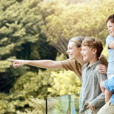 Happy, family and and pointing on balcony, parents and bonding with children, smile and love in home. Outdoor, mom and dad with kids, hand and glasses for man, summer and woman in property and house.